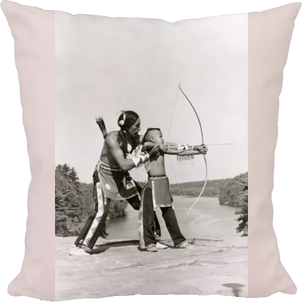 Young Native American Indian boy learning to shoot his bow