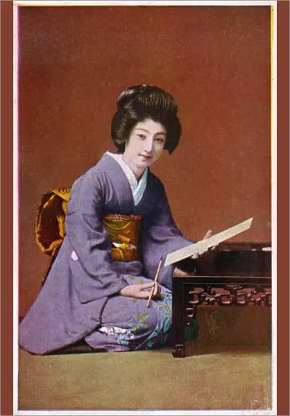 Japan - Geisha Girls kneels at her low writing table