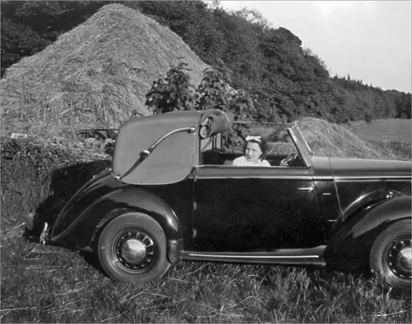 Woman in a car near a haystack