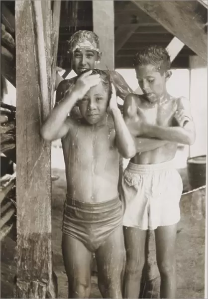 Boy scouts sharing a shower at camp, British Honduras