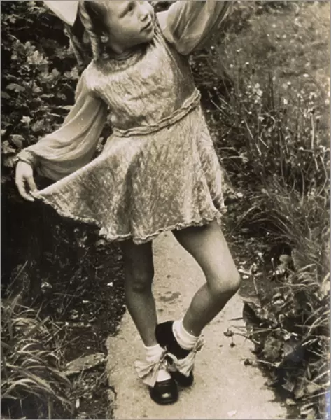 Little girl in costume, posing on a garden path
