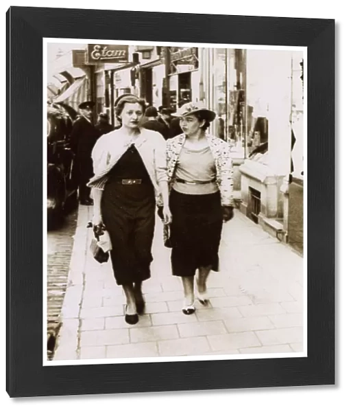 A pair of rich girls off shopping - passing an Etam Store