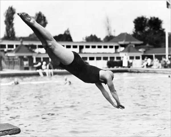 DIVE IN. A woman in a swimming costume dives into a lido! Date: 1930s