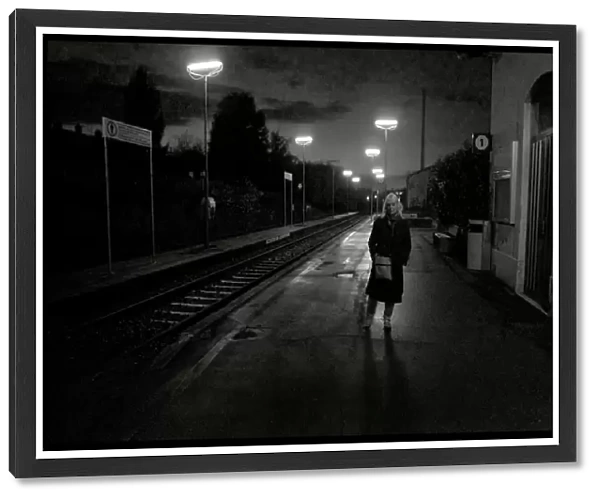 Woman on railway station platform late evening, Italy