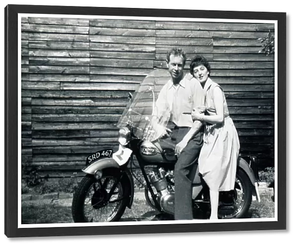 Man & woman on 1950s Triumph motorcycle