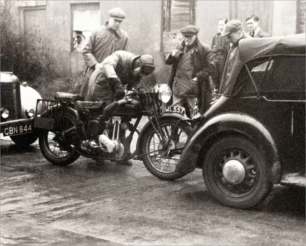 Men standing around an Ariel motorcycle