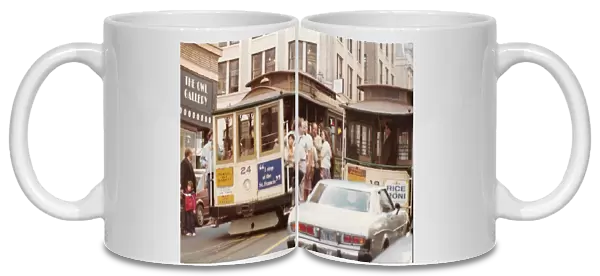 Two cable carts on a busy street in San Francisco