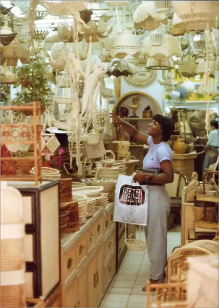 British Caribbean woman points to an item, novelty shop, Hon