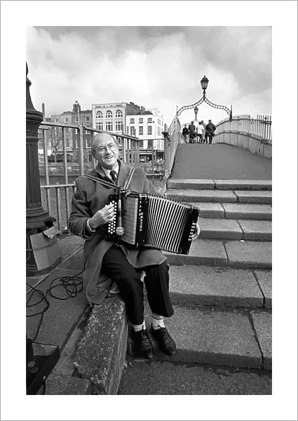 Busker plays an accordian on Ha penny Bridge, Dublin