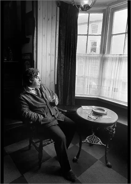 A customer sits with a drink in Browns Hotel, Laugharne