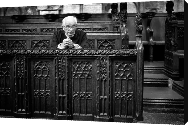 An elderly minister sits to pray in Bath Abbey, England