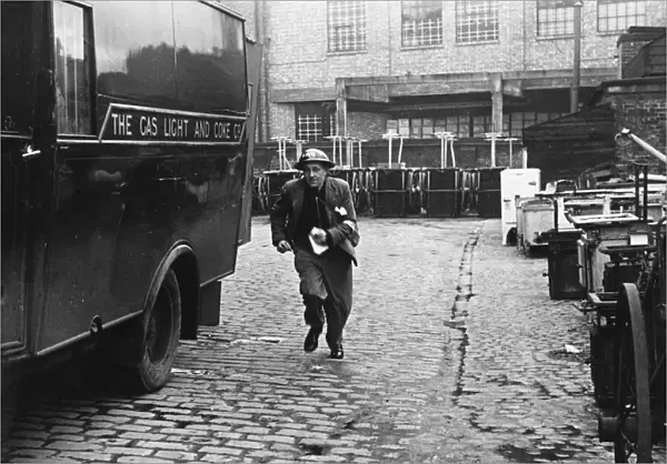 A messenger runs with the news that a gas main is on fire after an air raid during World