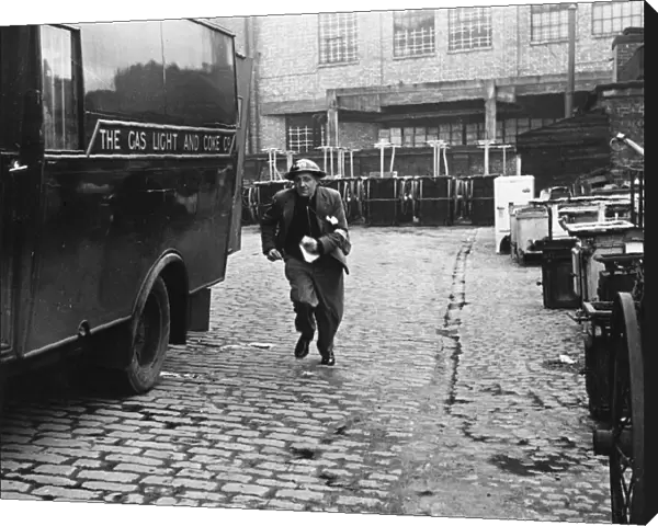 A messenger runs with the news that a gas main is on fire after an air raid during World