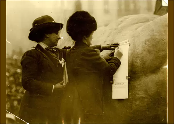Two suffragettes signing a petition