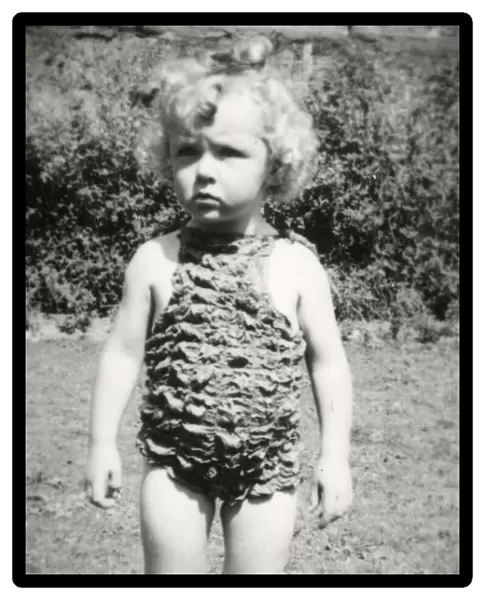 A little girl wearing a rather bizarre crimpled swimsuit
