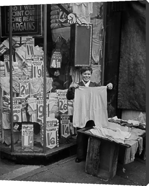Shop assistant shows garments for inspection, London
