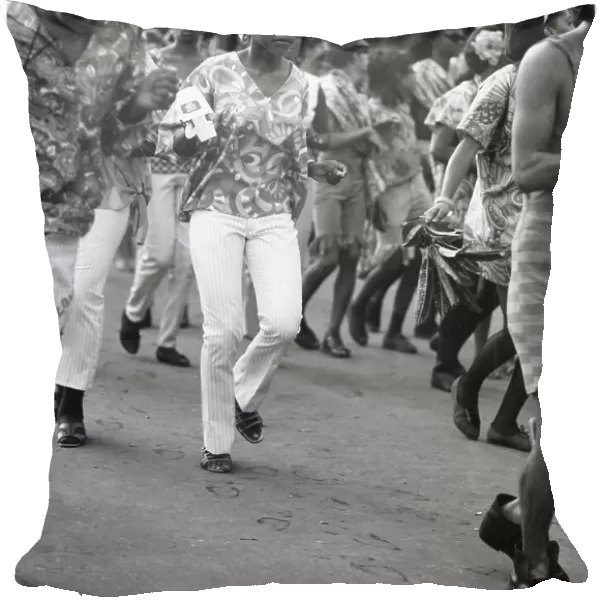 A young woman in trendy sunglasses dances with her friends at the Port of Spain Carnival, Trinidad, West Indies. Date: 1968