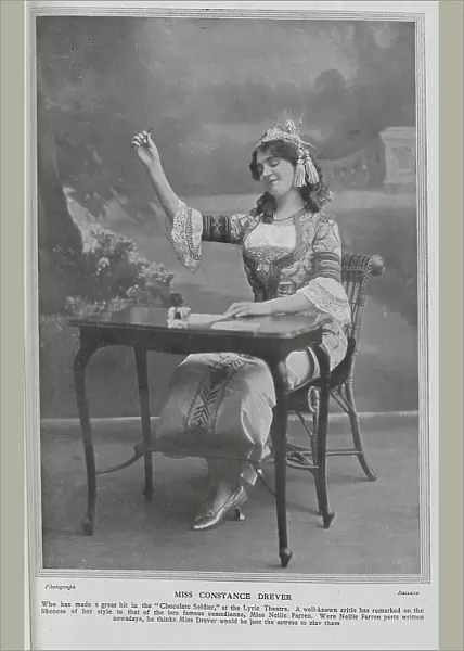 Constance Drever, actress (1880-1948), theatrical portrait, seated at writing desk. Miss Drever had made a recent hit in The Chocolate Soldier'at the Lyric Theatre, and had been compared to the late comedienne, Nellie Farren