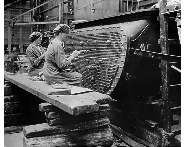 Women working on a condenser tube during the First World War
