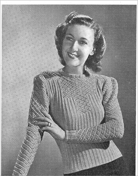 Model wearing a knitted sweater in a ribbed and lace pattern. Date: 1940