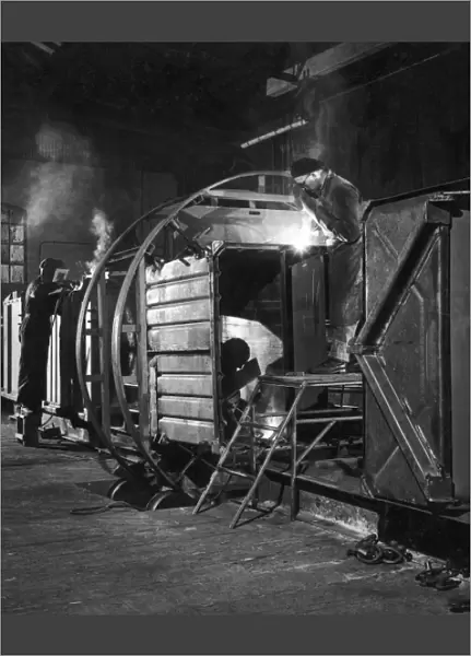 Metalworkers welding a railway carriage