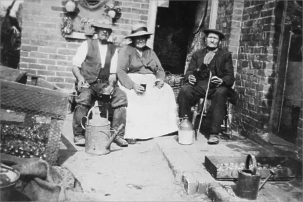 Three elderly people sitting outside their home