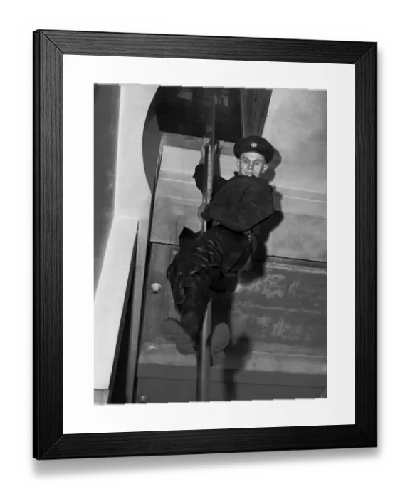 Framed Print : Print of a London Fire Brigade Fireman sliding down a pole