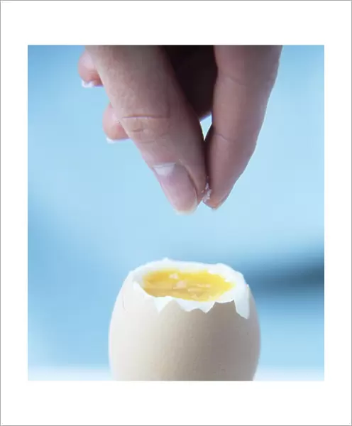 Salt being sprinkled onto a boiled egg