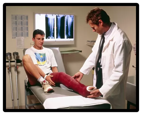 Doctor examining full leg cast of patient
