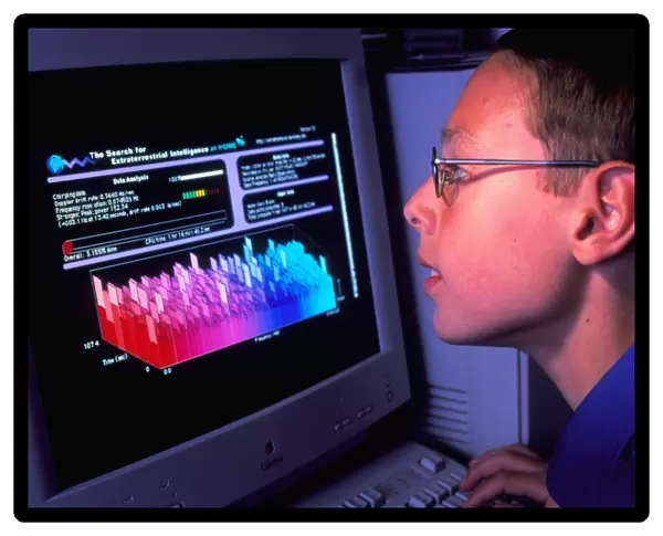 Boy at computer displaying SETI@home screen saver