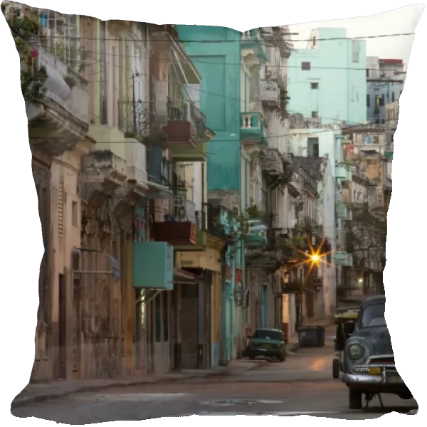 Street scene before sunrise showing dilapidated buildings crowded together and vintage American cars, Havana Centro, Havana, Cuba, West Indies, Caribbean, Central America