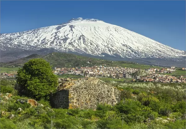 The 3350m snow-capped volcano Mount Etna, UNESCO World Heritage Site, looms over the Maletto town on its western flank, Maletto, Catania Province, Sicily, Italy, Europe