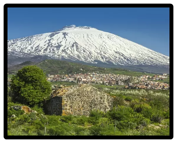 The 3350m snow-capped volcano Mount Etna, UNESCO World Heritage Site, looms over the Maletto town on its western flank, Maletto, Catania Province, Sicily, Italy, Europe