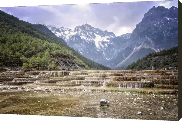Cascading falls at Baishuihe with Jade Dragon Snow Mountain backdrop, Lijiang, Yunnan, China, Asia
