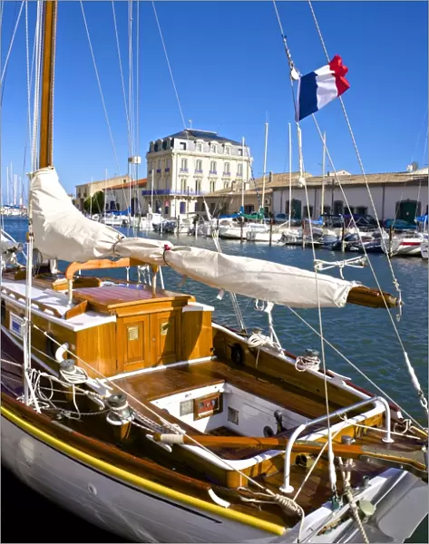 Tourist boats in marina, and French flag, in Marseillan harbor, Herault, Languedoc-Roussillon region, France, Europe