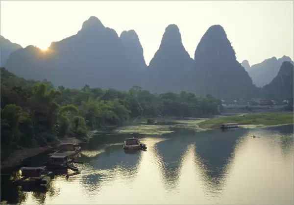 In Guilin limestone tower hills rise steeply above the Li River, Yangshuo