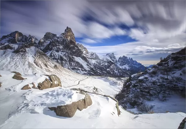 Cloudy winter sky on the snowy peaks of the Pale di San Martino, Rolle Pass, Panaveggio