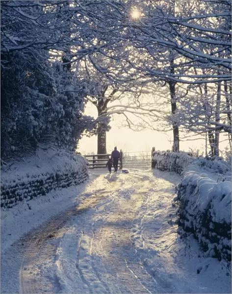 Man and child walking down a snow covered road in winter near Arthington