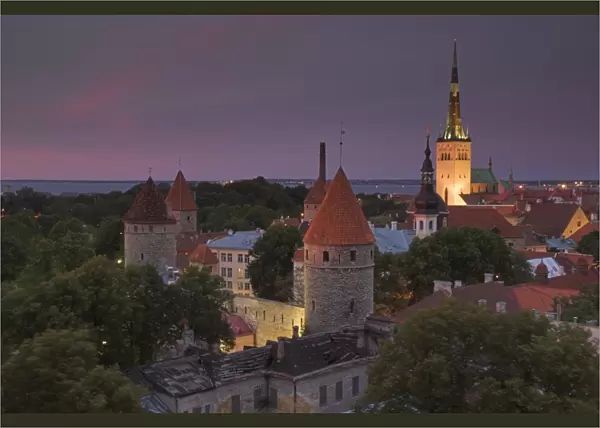 Medieval town walls, defence towers and spire of St. Olavs church at sunset