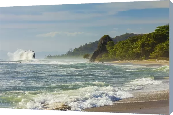 Surf breaking on sea stack and the Penon rock at this far south Nicoya Peninsula beach