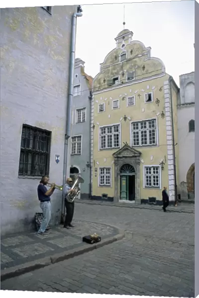 Street musicians play by the Three Brothers