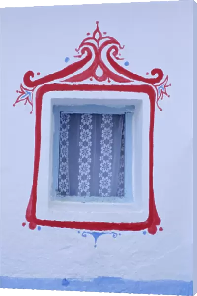 Decorated window in a white wall