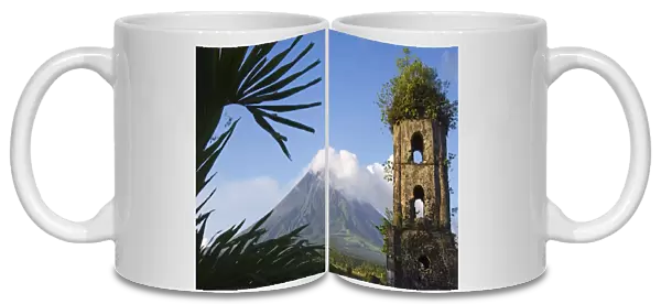 Church belfry ruins and volcanic cone with smoke plume of Mount Mayon