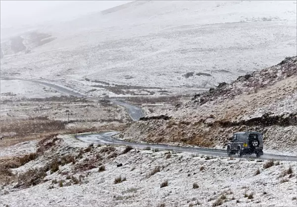 A four wheel drive vehicle negotiates a road through a wintry landscape in the Elan