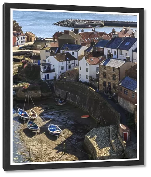Winding alleys of village, fishing boats and sea, elevated view in summer, Staithes