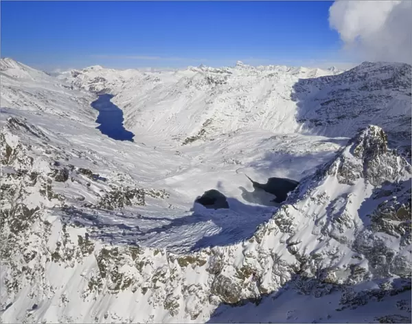 Aerial view of snowy Peak Peloso surrounded by Lago di Lei, Val di Lei Chiavenna