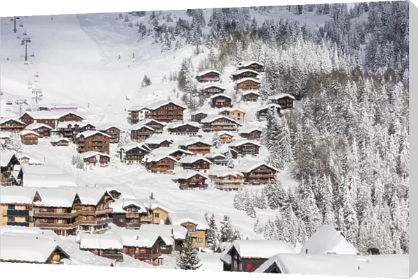Snowy woods frame the typical alpine village and ski resort, Bettmeralp, district of Raron