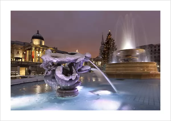Trafalgar Square at Christmas in snow at night, London, England, United Kingdom, Europe