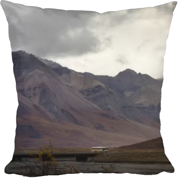 Tourist bus driving among mountains in the Denali National Park, Alaska, United States of America