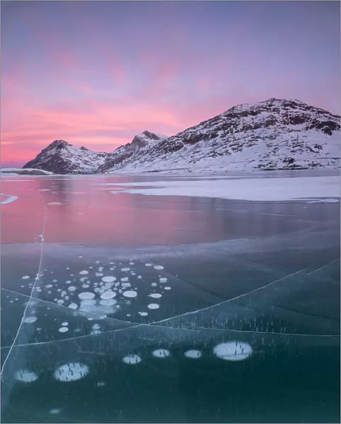 Panorama of ice bubbles and frozen surface of Lago Bianco at dawn, Bernina Pass